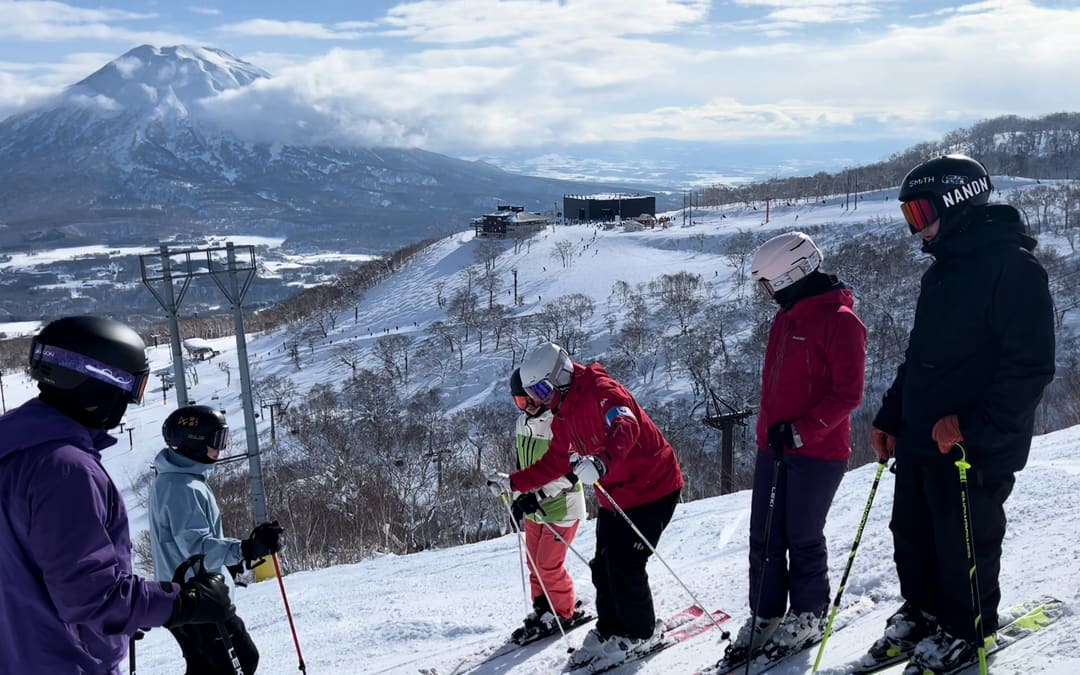 教練在羊蹄山前的雪道上為學員示範動作